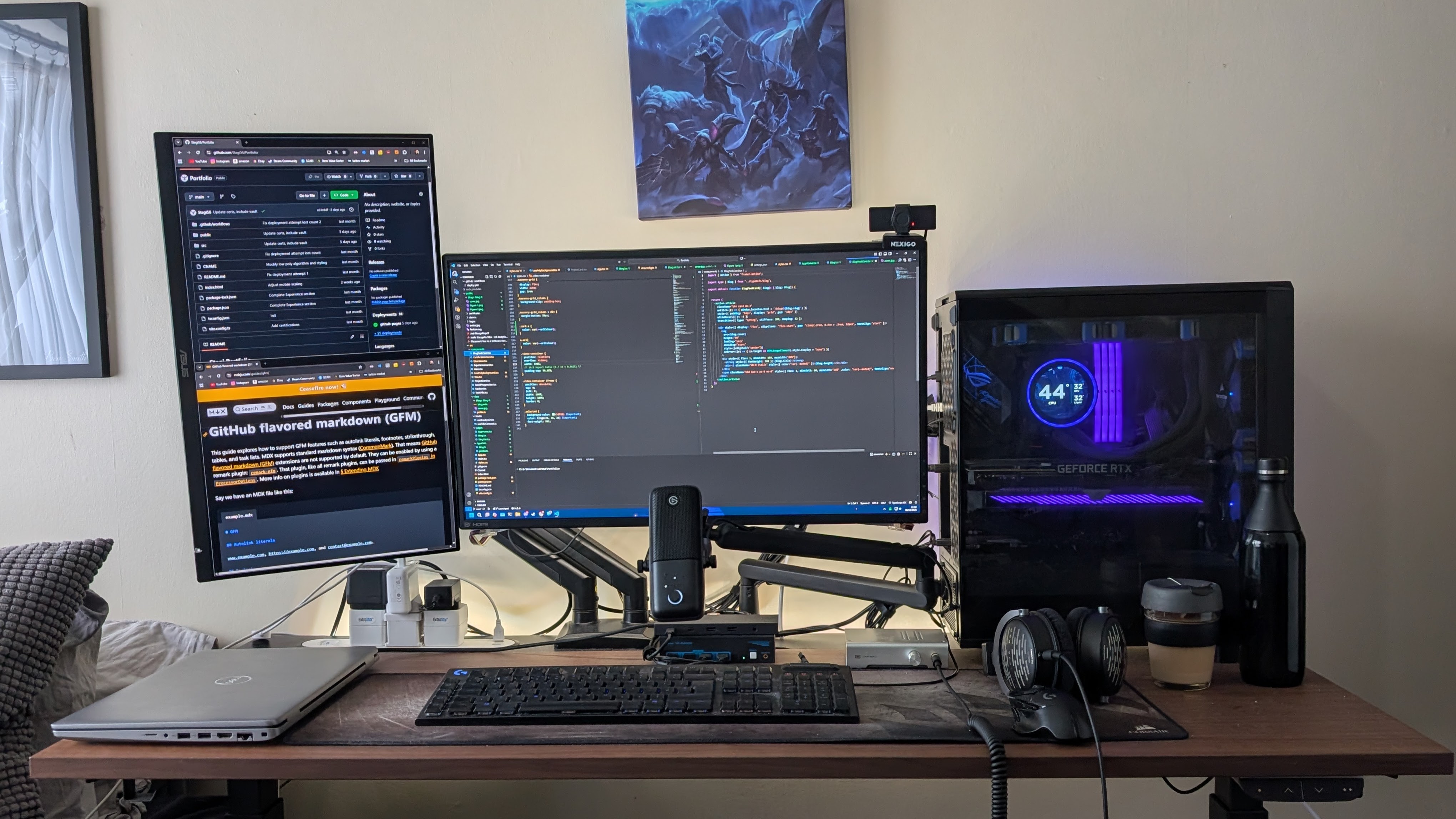 Home workstation with two monitors, a desktop computer, microphone, keyboard and laptop